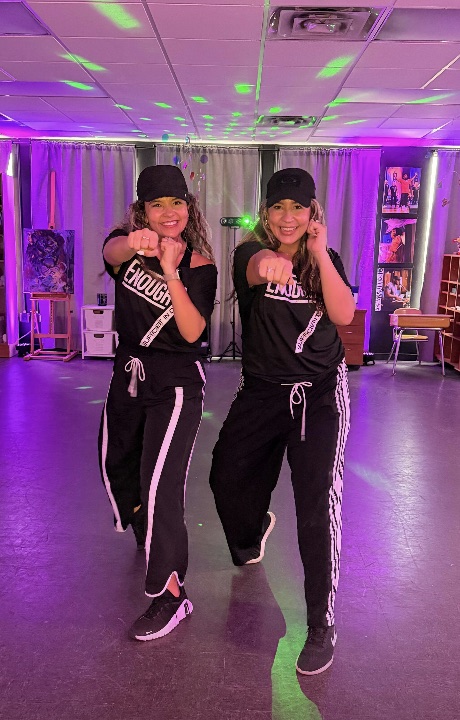 The Enough7Fitness duo mid-routine under the class lights